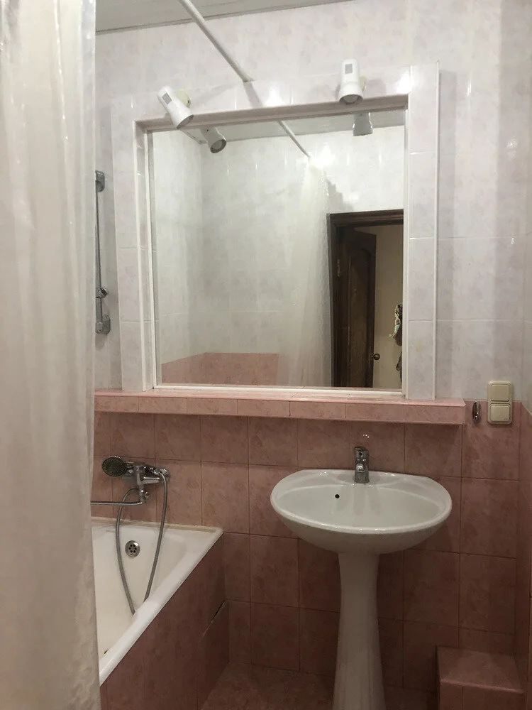 Altes Badezimmer mit Waschbecken Badewanne und alten rosa Fliesen vor der Vollsanierung